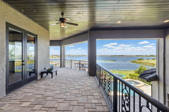 balcony featuring french doors, a water view, and a ceiling fan