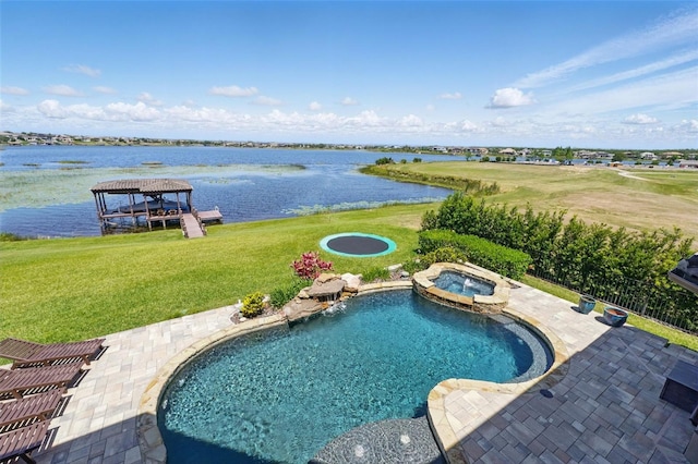 view of pool with a yard, a pool with connected hot tub, a patio, and a water view