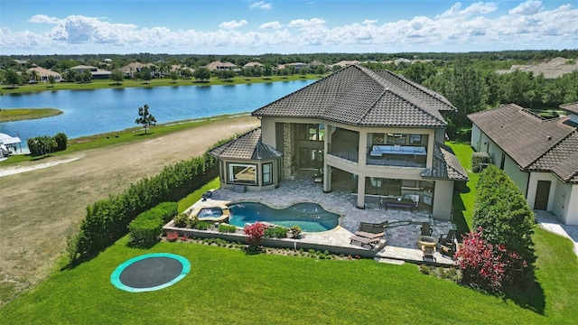 exterior space with a tile roof, a lawn, a water view, and a balcony