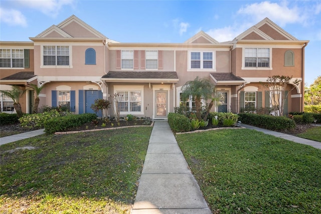 multi unit property with a front lawn and stucco siding