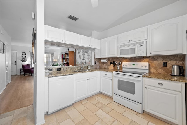 kitchen with visible vents, white cabinets, a sink, dark stone countertops, and white appliances