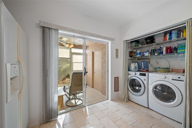 washroom with laundry area, washing machine and clothes dryer, and stone tile flooring