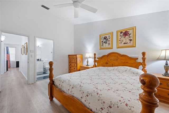 bedroom with visible vents, connected bathroom, and wood finished floors