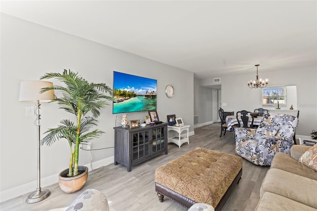 19029 US Highway 19 N Unit 7-9, Clearwater, FL 33764 - living room featuring light wood-style floors, visible vents, baseboards, and a notable chandelier