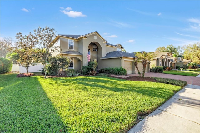 view of front of property featuring a garage, fence, decorative driveway, stucco siding, and a front yard