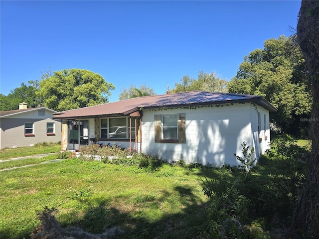 view of front facade with metal roof and a front yard