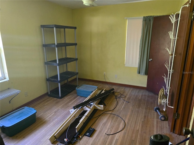 workout room with baseboards and hardwood / wood-style flooring