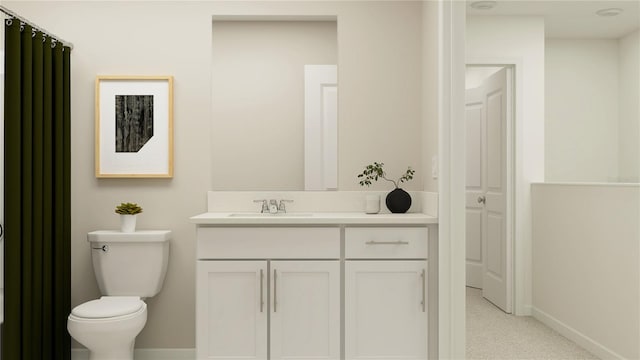 bathroom with toilet, vanity, and baseboards