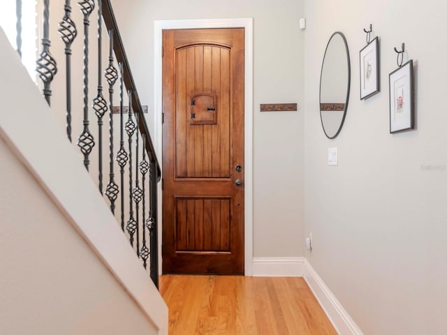 entrance foyer featuring stairway, light wood-style flooring, and baseboards