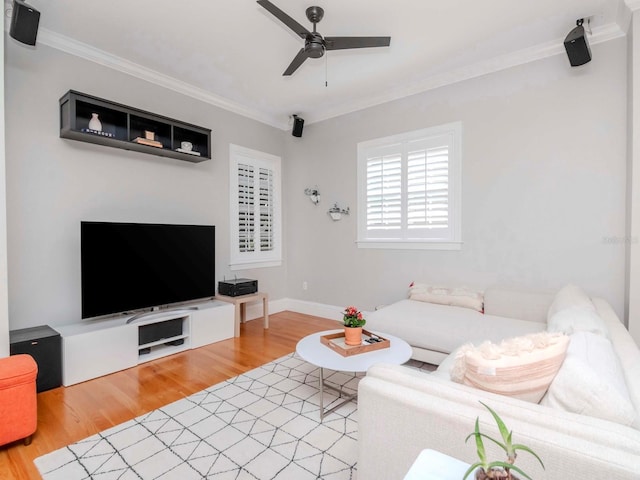 living area with baseboards, wood finished floors, a ceiling fan, and ornamental molding