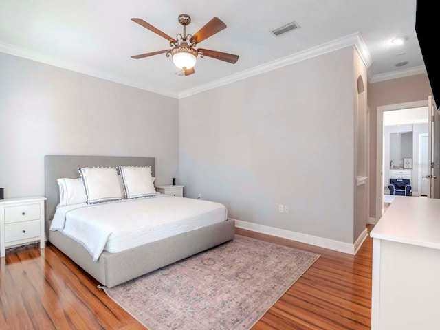 bedroom with light wood-type flooring, visible vents, ornamental molding, baseboards, and ceiling fan