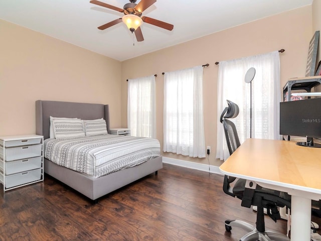 bedroom featuring baseboards, wood finished floors, and a ceiling fan