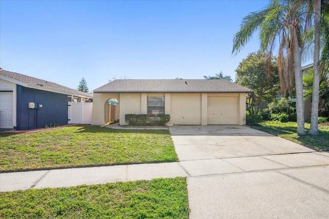 view of front of house with a front yard, fence, driveway, and stucco siding