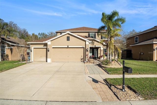 traditional-style home with a garage, driveway, a front yard, and stucco siding