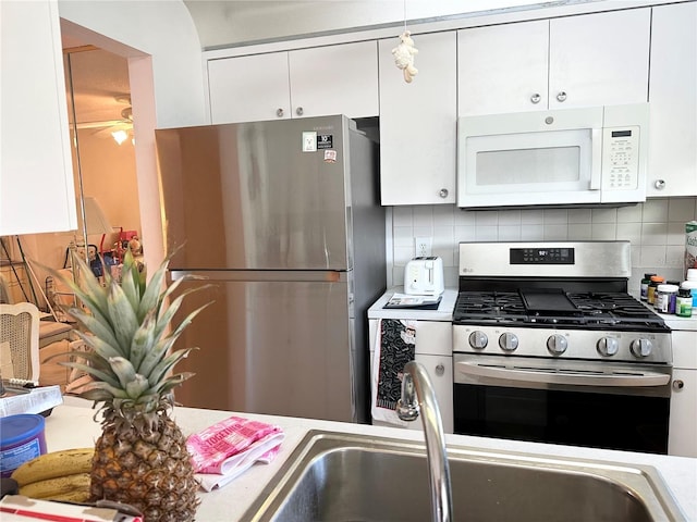 kitchen featuring white cabinetry, appliances with stainless steel finishes, decorative backsplash, and light countertops