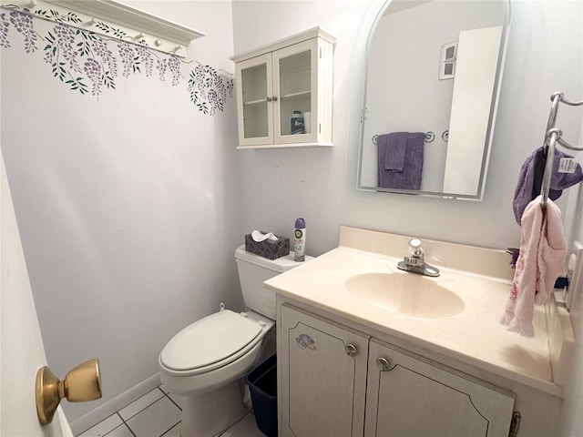 bathroom featuring baseboards, vanity, toilet, and tile patterned floors