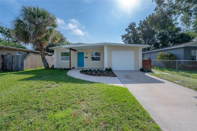 view of front of property featuring a garage, driveway, fence, a front yard, and stucco siding