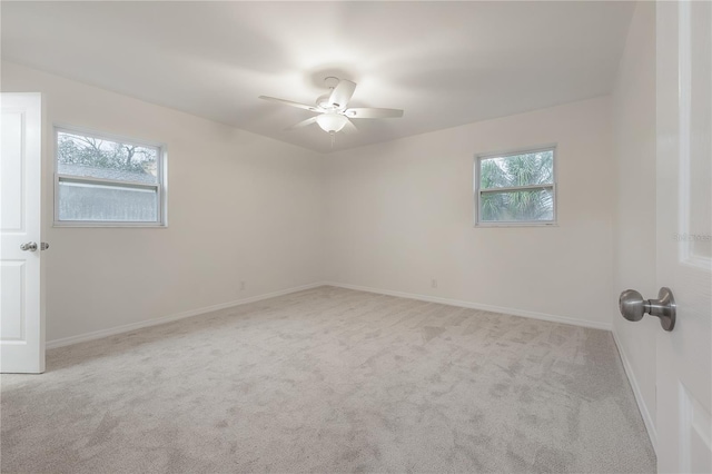 unfurnished room with a ceiling fan, a wealth of natural light, baseboards, and carpet