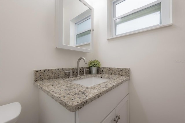 half bath featuring toilet and vanity