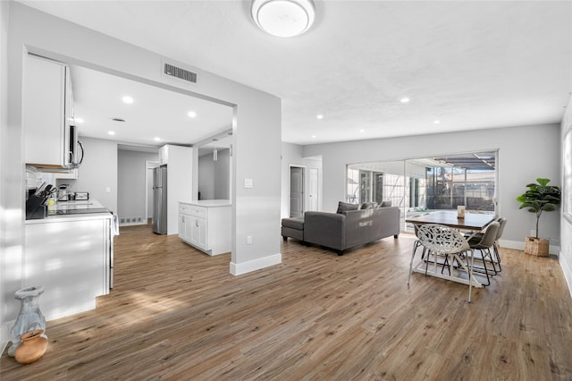 living area featuring recessed lighting, baseboards, visible vents, and light wood finished floors