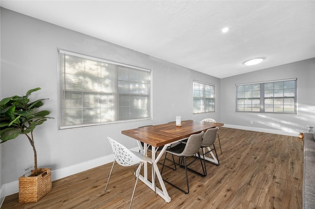 dining room with lofted ceiling, baseboards, and wood finished floors