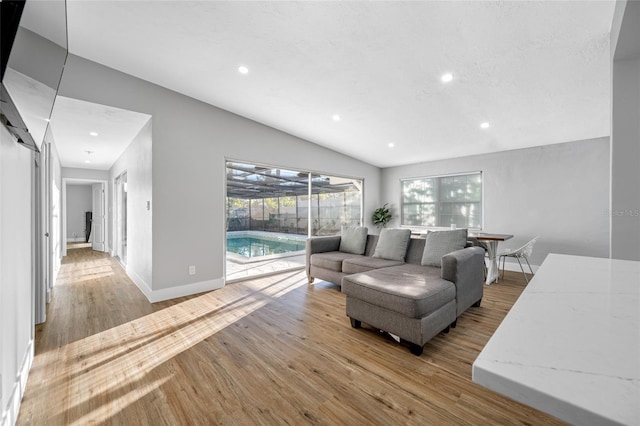 living area with lofted ceiling, baseboards, recessed lighting, and wood finished floors