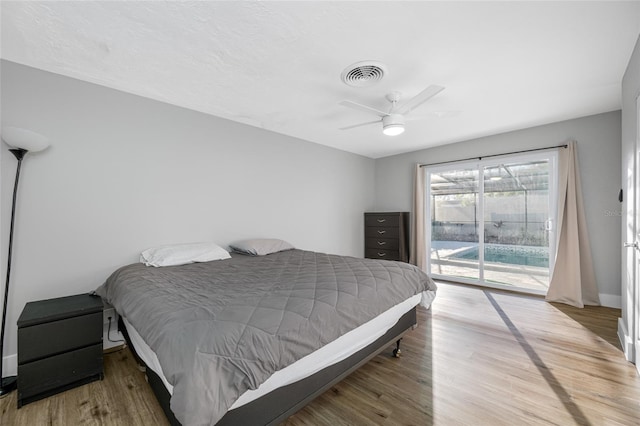 bedroom featuring a ceiling fan, wood finished floors, visible vents, and access to exterior