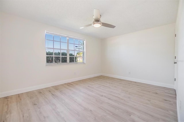 unfurnished room with ceiling fan, baseboards, and light wood-style flooring