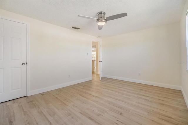 unfurnished room featuring a ceiling fan, light wood-style floors, visible vents, and baseboards