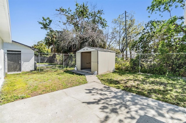 view of yard with an outbuilding, a shed, a patio, and a fenced backyard