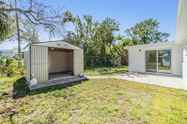 view of yard with a fenced backyard, a patio area, a storage unit, and an outdoor structure