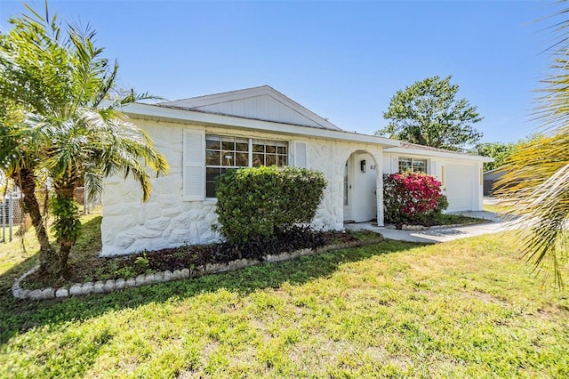 single story home with a front yard and an attached garage