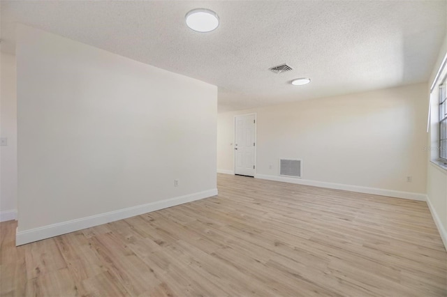 spare room with light wood-style flooring, baseboards, and visible vents