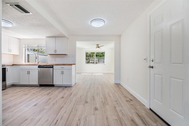 kitchen featuring visible vents, butcher block countertops, tasteful backsplash, dishwasher, and a healthy amount of sunlight