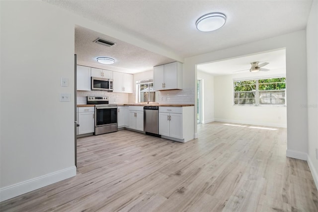 kitchen with visible vents, backsplash, appliances with stainless steel finishes, and a healthy amount of sunlight