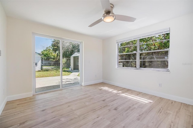 spare room with plenty of natural light, wood finished floors, and baseboards