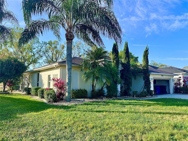 view of front of home with a garage, a front yard, and stucco siding