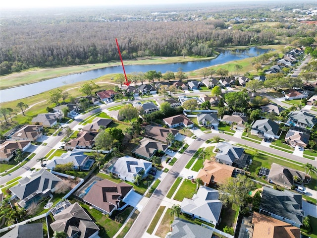 drone / aerial view featuring view of golf course, a water view, and a residential view