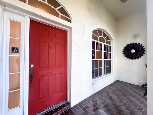 view of exterior entry featuring stucco siding