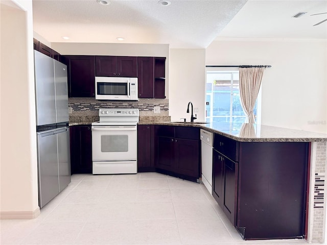 kitchen featuring white appliances, stone countertops, visible vents, a peninsula, and open shelves