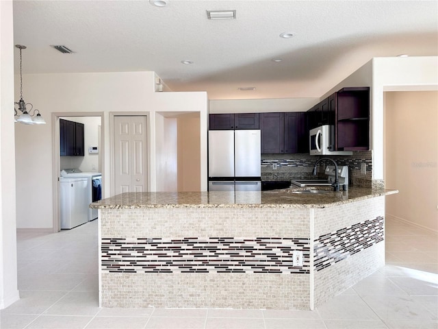 kitchen featuring light tile patterned floors, visible vents, freestanding refrigerator, open shelves, and washer and clothes dryer