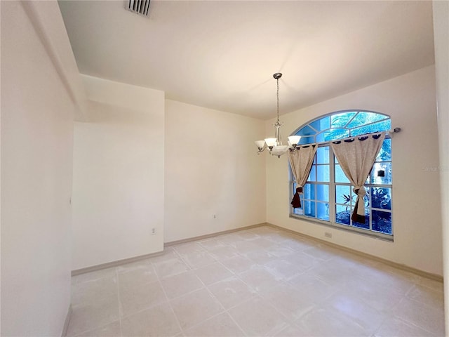 empty room featuring a notable chandelier, visible vents, and baseboards