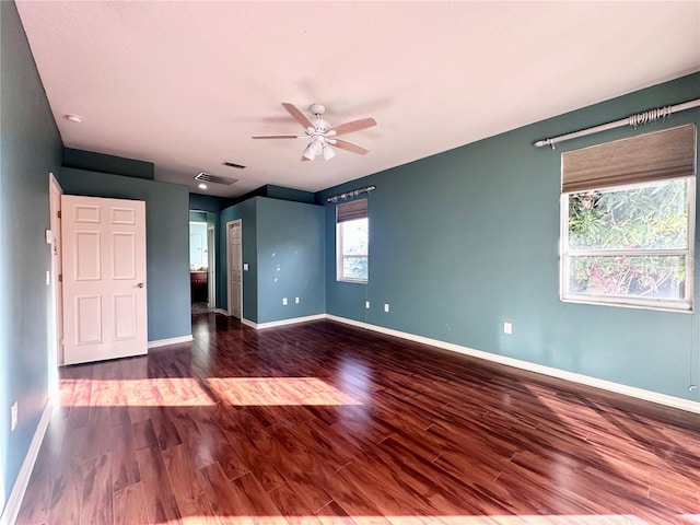 spare room featuring ceiling fan, wood finished floors, visible vents, and baseboards