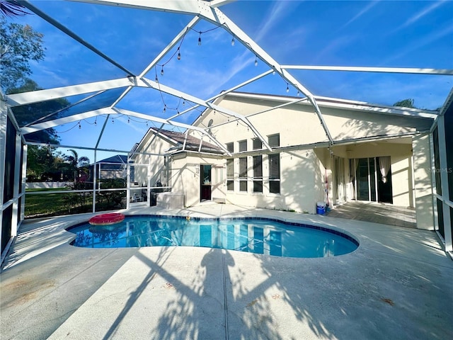 outdoor pool with a lanai and a patio area