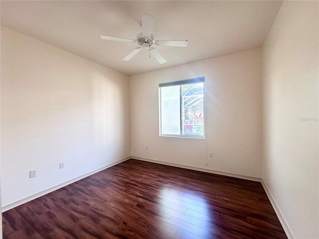 spare room featuring ceiling fan, baseboards, and wood finished floors