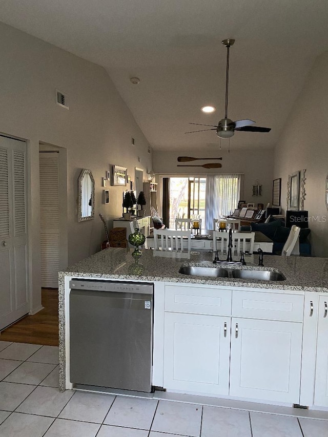 kitchen featuring light stone counters, visible vents, stainless steel dishwasher, open floor plan, and a sink