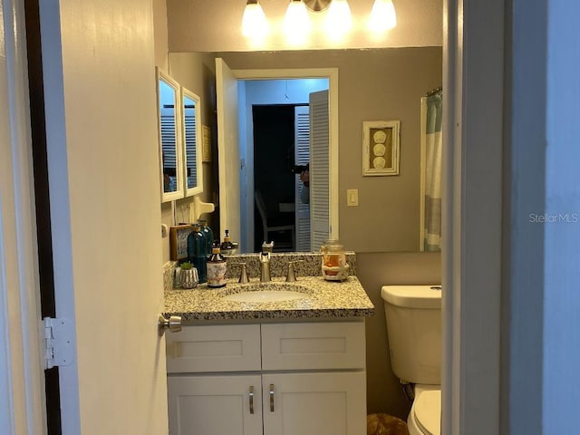 bathroom featuring vanity and toilet