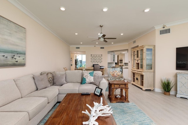 living area with light wood-style flooring, visible vents, and crown molding