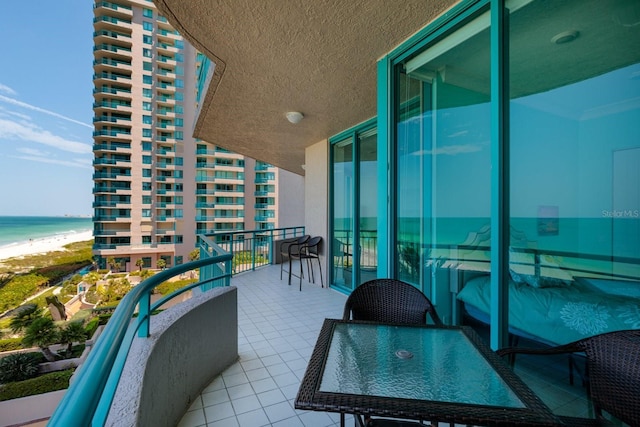 balcony with a water view and a beach view