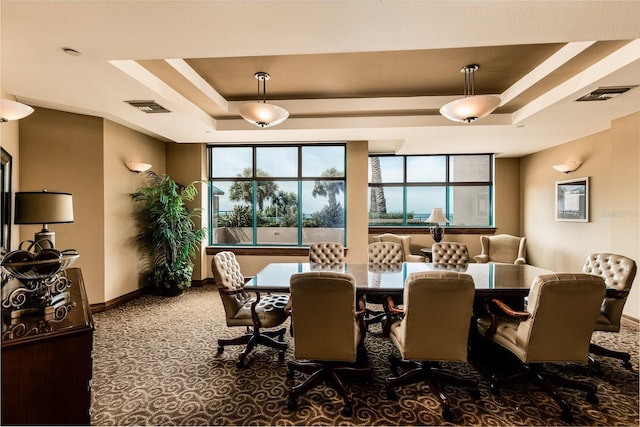 carpeted dining area featuring visible vents, a tray ceiling, and baseboards